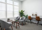 Thumbnail 19 of 30 - a living room with chairs and a table and windows