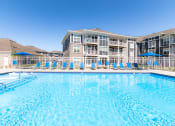 Thumbnail 25 of 30 - our apartments have a large pool with blue chairs
