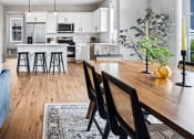 Thumbnail 3 of 30 - a kitchen and dining room with white cabinets and a table