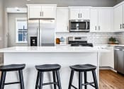 Thumbnail 2 of 30 - a kitchen with a counter top and three stools