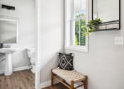 Thumbnail 11 of 30 - a small bathroom with a window and a chair and a sink