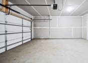 Thumbnail 14 of 30 - an empty garage with white walls and a door