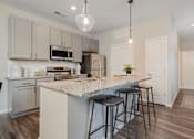 Thumbnail 5 of 43 - A kitchen with a granite countertop and bar stools.