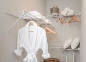 Thumbnail 13 of 43 - A white robe is hanging on a rack in a small room.