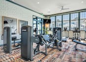 Thumbnail 33 of 43 - A gym with a variety of equipment including a squat rack, bench, and weights.