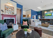Thumbnail 19 of 43 - A living room with a fireplace and a painting on the wall.
