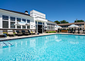 Thumbnail 37 of 43 - A swimming pool in front of a building with a white facade.