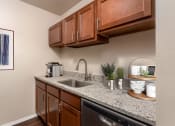 Thumbnail 4 of 10 - a kitchen with granite counter tops and wooden cabinets