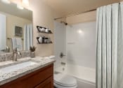 Thumbnail 6 of 10 - a bathroom with a shower and a sink and a toilet