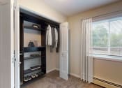 Thumbnail 19 of 34 - a closet in a bedroom with a window and a closet door