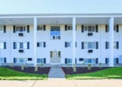 Thumbnail 33 of 34 - a white apartment building with a sidewalk and grass