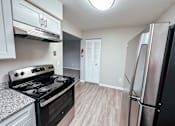 Thumbnail 1 of 34 - A kitchen with a black stove top oven and a refrigerator.
