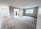 Thumbnail 3 of 34 - A carpeted room with a door and a window.