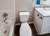 Thumbnail 9 of 34 - A white toilet sits next to a sink in a bathroom.