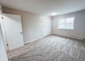 Thumbnail 4 of 34 - A room with a carpeted floor and a window with blinds.