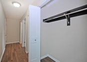 Thumbnail 22 of 34 - a bedroom with a closet and a white door and a hallway with wood floors