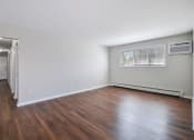 Thumbnail 17 of 34 - an empty living room with wood floors and a window