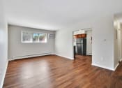 Thumbnail 15 of 34 - an empty living room with wood flooring and a kitchen