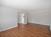 Thumbnail 16 of 34 - the spacious living room with wood flooring and white walls