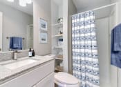 Thumbnail 5 of 30 - a bathroom with a shower and a sink and a toilet
