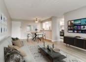 Thumbnail 3 of 30 - a living room with a couch and a coffee table in front of a dining area