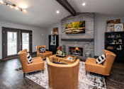 Thumbnail 26 of 30 - A modern living room with a fireplace and a painting above it.