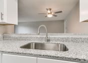 Thumbnail 11 of 30 - a kitchen with a sink and a ceiling fan