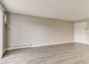 Thumbnail 17 of 30 - an empty living room with wood floors and white walls