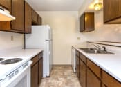 Thumbnail 22 of 30 - the preserve at ballantyne commons apartment kitchen with white appliances and wooden cabinets