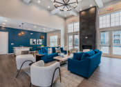 Thumbnail 16 of 30 - clubhouse with large windows blue sofas and gray chairs