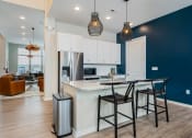 Thumbnail 14 of 30 - apartment clubhouse kitchen with island barstools and stainless steel fridge