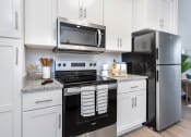 Thumbnail 1 of 30 - a kitchen with a stove and a microwave