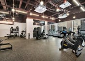 Thumbnail 24 of 29 - a gym with various exercise equipment and lights on the ceiling