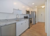 Thumbnail 16 of 29 - a renovated kitchen with white cabinets and stainless steel appliances