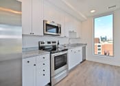 Thumbnail 17 of 29 - a kitchen with white cabinets and stainless steel appliances and a window