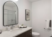Thumbnail 22 of 29 - a bathroom with a sink and a mirror and a toilet