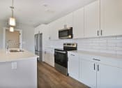 Thumbnail 8 of 38 - a kitchen with white cabinets and a sink and a refrigerator