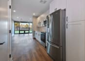 Thumbnail 10 of 38 - a renovated kitchen with stainless steel appliances and white cabinets