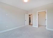 Thumbnail 15 of 38 - a bedroom with a carpeted floor and a door to a hallway