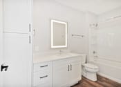Thumbnail 33 of 38 - A white bathroom with a toilet, sink, and bathtub.