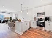 Thumbnail 35 of 38 - A modern kitchen with white cabinets and stainless steel appliances.