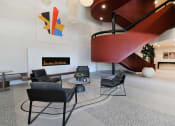 Thumbnail 26 of 38 - a living room with chairs and a fireplace and a spiral staircase
