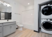 Thumbnail 21 of 29 - bathroom with a tub and washer and dryer