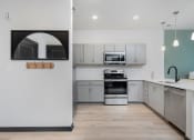 Thumbnail 2 of 29 - a kitchen with white cabinets and stainless steel appliances