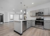 Thumbnail 16 of 29 - a large kitchen with white cabinets and stainless steel appliances