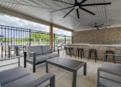 Thumbnail 43 of 50 - A patio with a table, chairs, and a ceiling fan.
