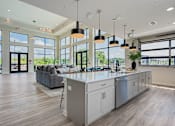Thumbnail 17 of 50 - A modern kitchen with a large island and pendant lights.