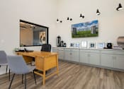 Thumbnail 27 of 50 - A room with a desk and chairs with a picture of a river ridge on the wall.