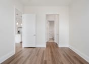 Thumbnail 7 of 40 - a bedroom with hardwood floors and white walls