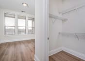 Thumbnail 22 of 40 - a bedroom with hardwood floors and white walls